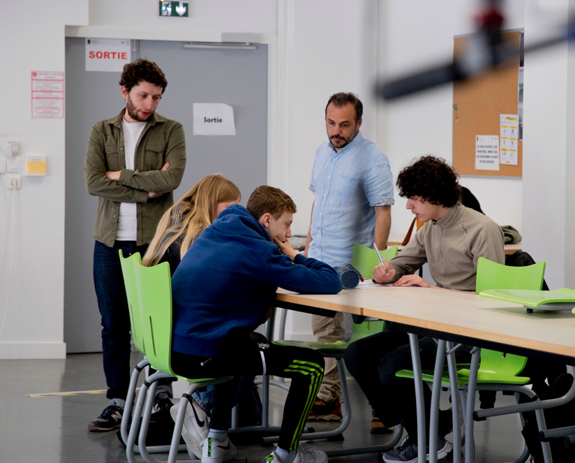 lycéens en train de travailler à une table dans un lycée