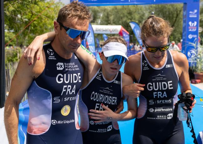 Cyril Viennot (à gauche) et Anne Henriet (à droite), soutiennent Héloïse Courvoisier, épuisée à l’issue de la manche de coupe du Monde d’Osselle, le 15 juin dernier - Photo Xavier Ducordeaux